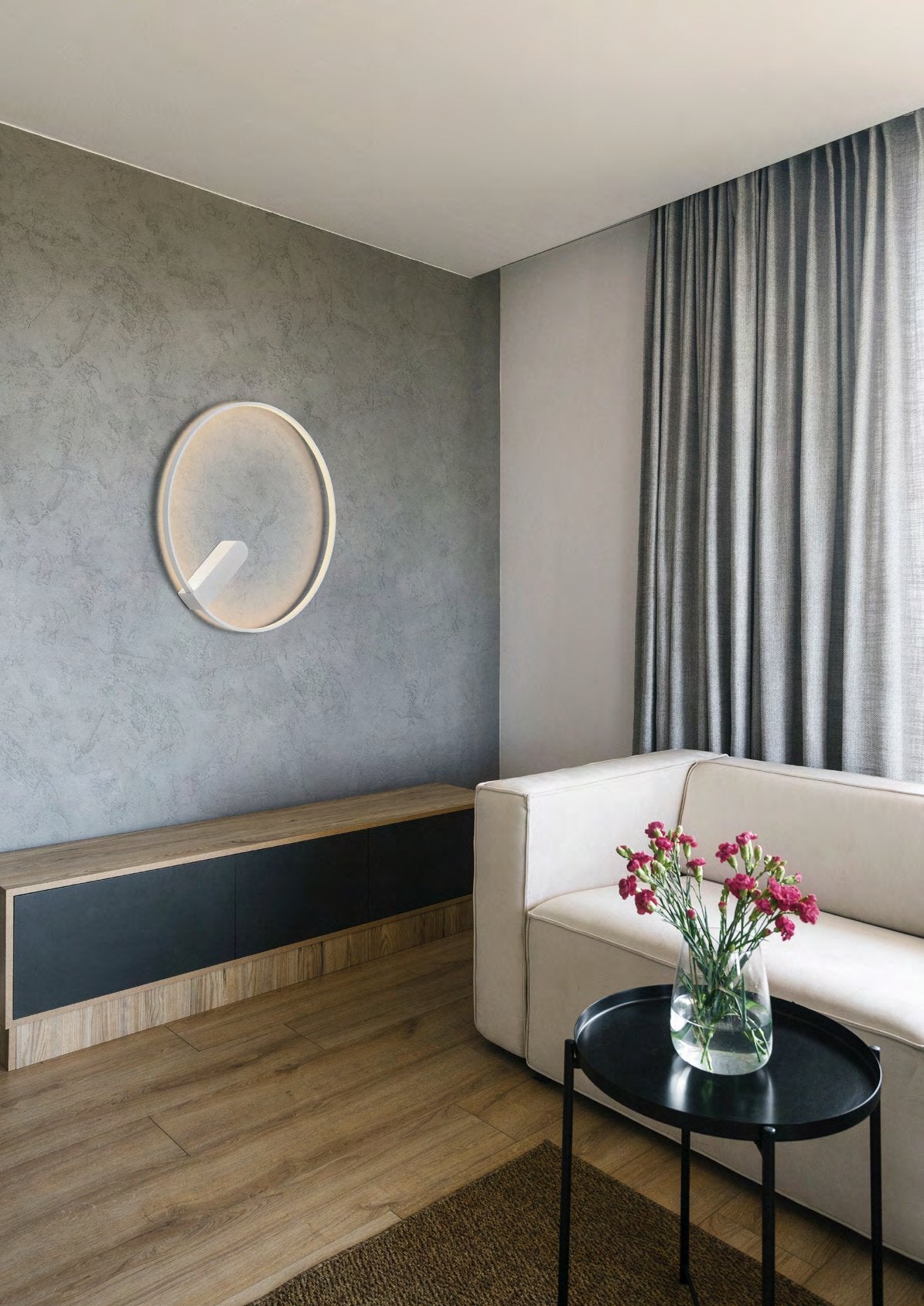 Holtkötter Circular S Weiß – LED-Lichtring Ø 50 cm an einer Betonwand im Wohnraum